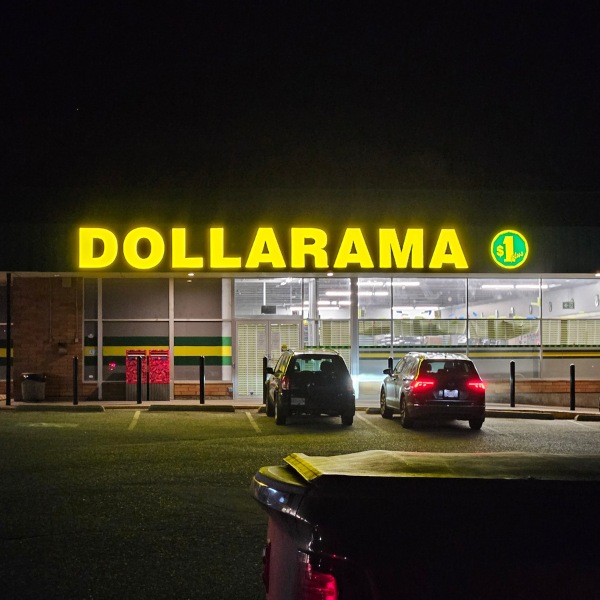Dollarama's signage on a building in yellow, at night.
